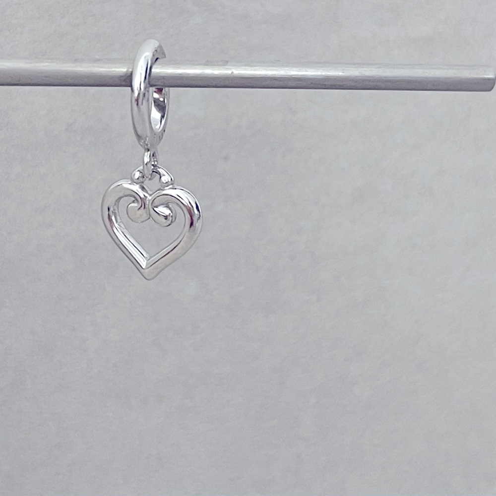 Silver NEW dangling charm with jewelry pouch.